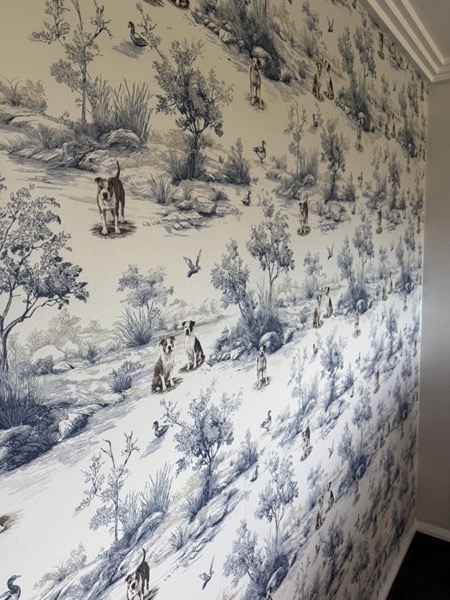 A hand-drawn bush scene wallpaper turning the corner of a bedroom