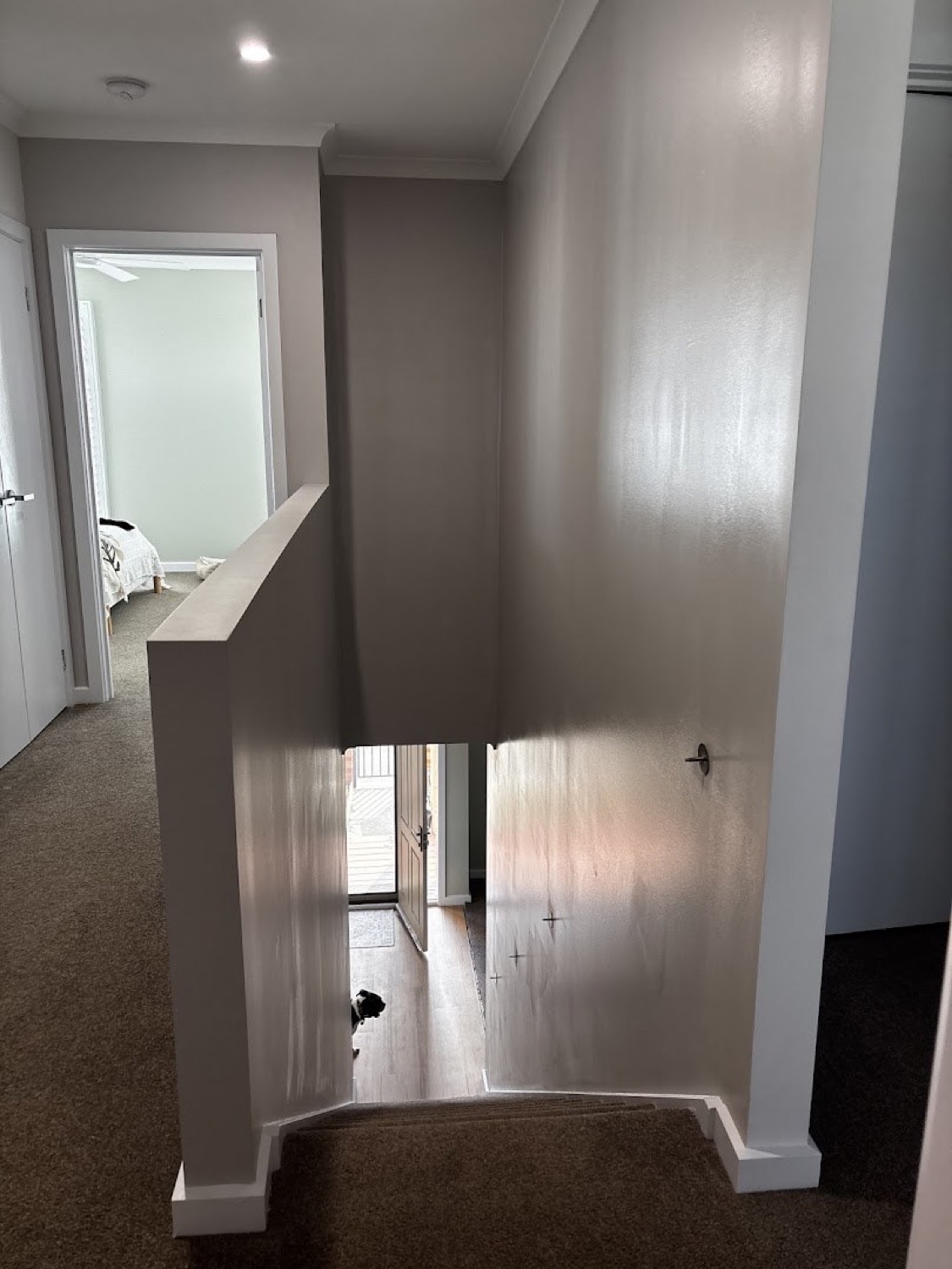 A stairwell void with soft grey walls and white trims
